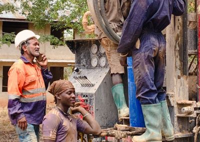 Vier Männer bedienen eine Maschine zum Bohren von Brunnen