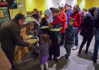 People line up to receive food on plates - helping in Germany