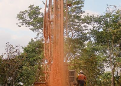 Water shooting several metres high out of a wellbore, where the machinery is still operating